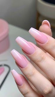 A close-up view of elegantly manicured pink acrylic nails, perfectly shaped and glossy, showcasing a delicate ombre effect from light to deeper pink. The nails are displayed against a soft, blurred background that simulates a serene salon atmosphere, with hints of pastel colors and a few beauty tools subtly positioned to suggest a professional environment. Soft, natural lighting highlights the shine and texture of the acrylics while casting gentle shadows to enhance the depth of the image. The overall mood is chic and sophisticated, emphasizing the elegance of simple pink nails and the importance of flawless application. elegantly manicured pink acrylic nails, perfectly shaped and glossy, showcasing a delicate ombre effect from light to deeper pink